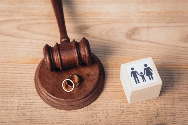 Top view of golden rings on gavel near wooden cube with family Top view of golden rings on gavel near wooden cube with family
