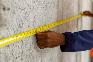 man measuring the wall