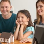Happy family with real estate agent in office