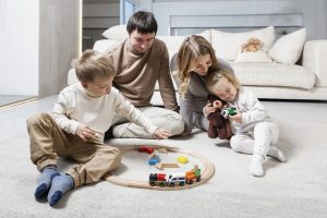 Happy young family with small children are sitting and playing