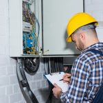 Professional electrician inspecting wires in electrical box