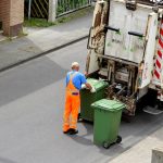 Worker loads paper-bins in a truck
