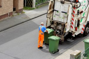 Worker loads paper-bins in a truck