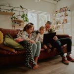Young family with daughter watching video on laptop