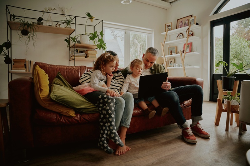 Young family with daughter watching video on laptop