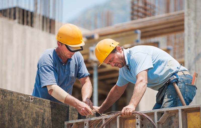 Construction workers working on cement formwork frames Construction workers working on cement formwork frames