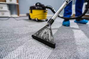Photo Of Janitor Cleaning Carpet With Vacuum Cleaner