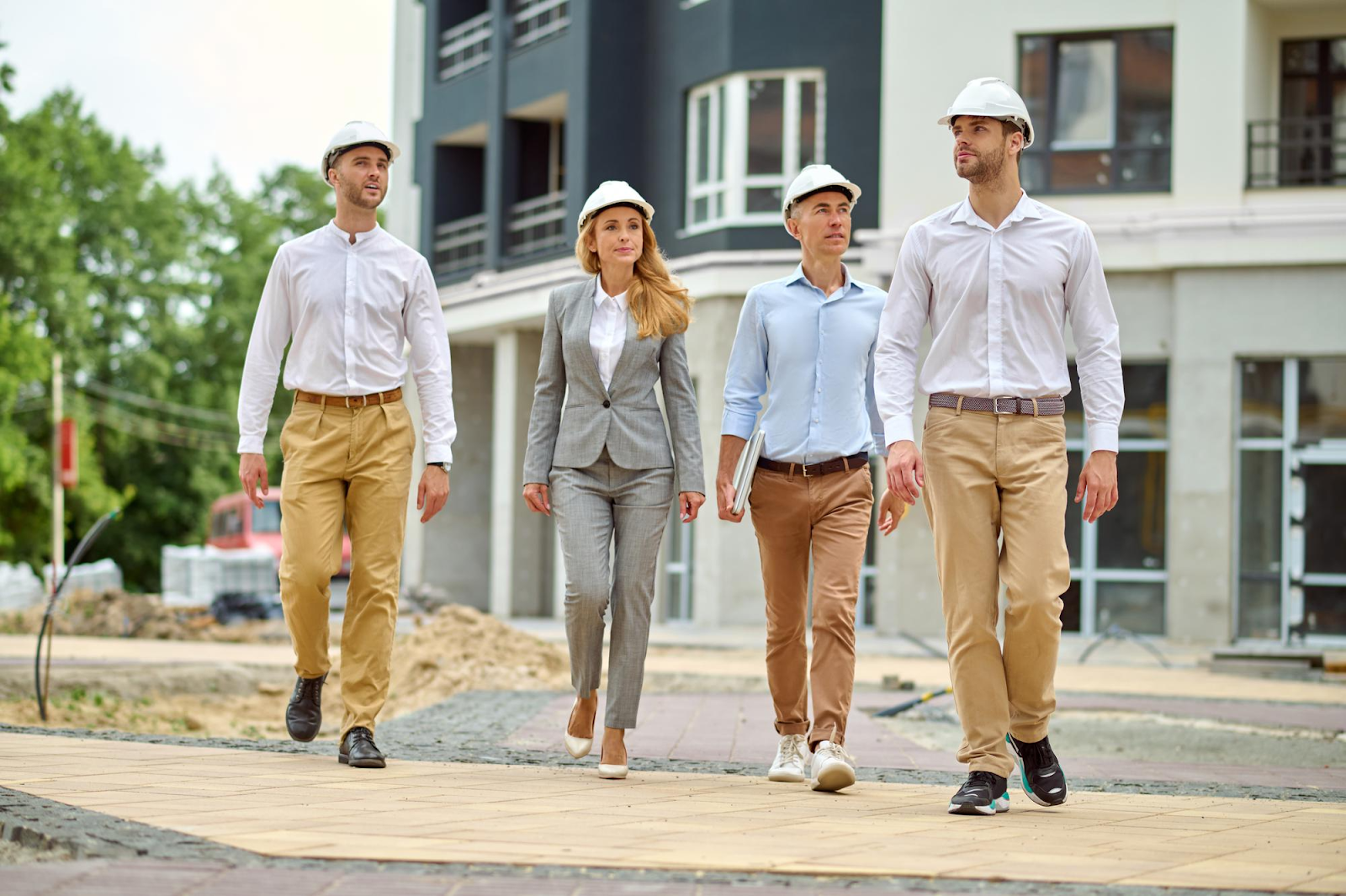 people walking on construction site with helments on