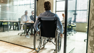 Rear view of a man in wheelchair entering the office.