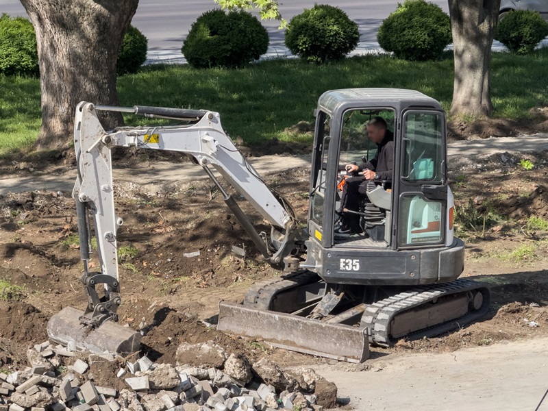 Worker operating compact excavator