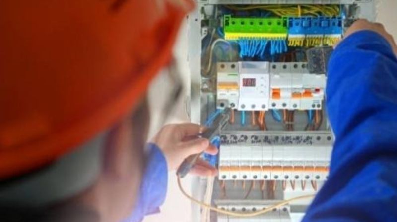 electrician working on an open electrical breaker panel