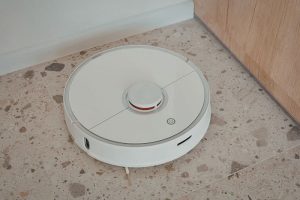 white-robot-vacuum-on-concrete-floor