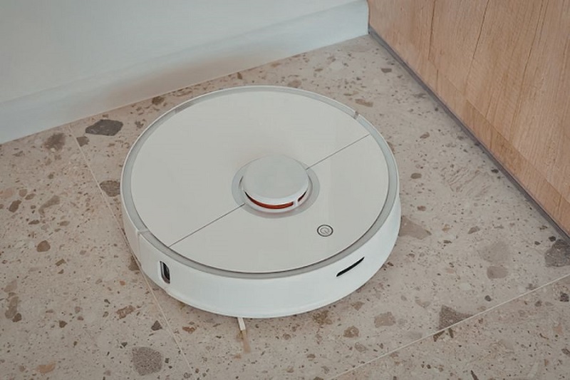 white-robot-vacuum-on-concrete-floor