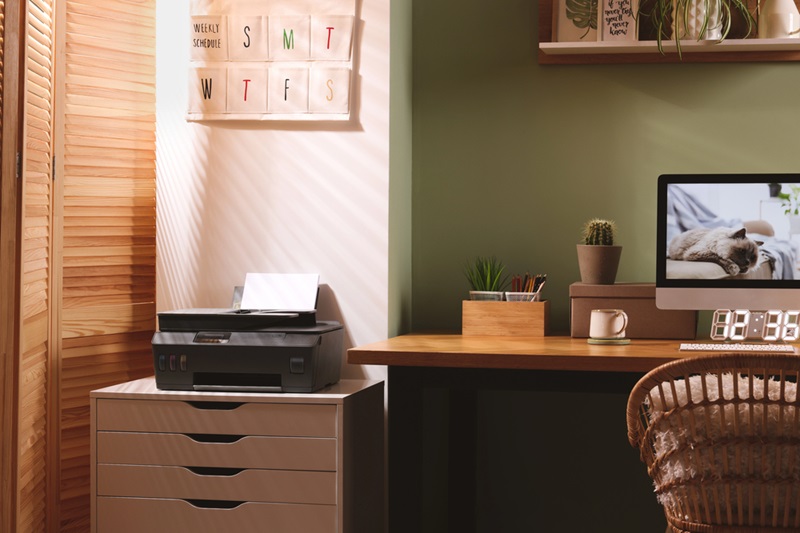 Stylish workplace with computer printer and houseplant