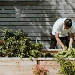 man in white t-shirt and black pants planting