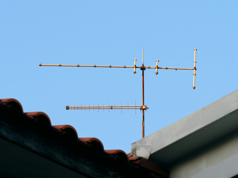An old television antenna on a rooftop An old television antenna on a rooftop
