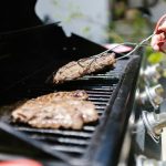 Close-up of juicy steaks grilling on a barbecue, perfect for summer cookouts