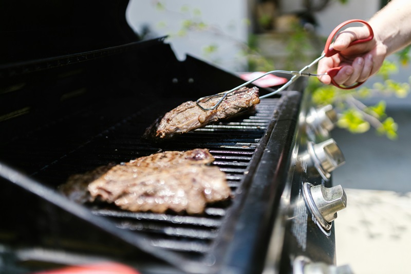 Close-up of juicy steaks grilling on a barbecue, perfect for summer cookouts Close-up of juicy steaks grilling on a barbecue, perfect for summer cookouts