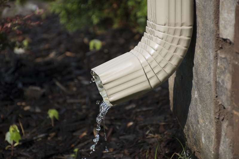 Gutter Downspout with water – side view Gutter Downspout with water - side view