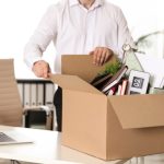 Man with a box of stuff in an office