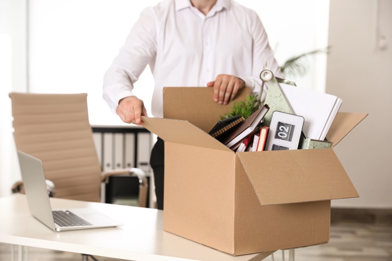Man with a box of stuff in an office