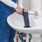 Plumber unclogging the sink