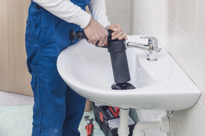 Plumber unclogging the sink