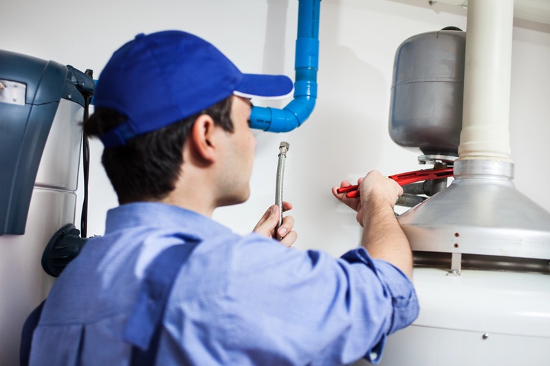 Professional Plumber Repairing a Hot Water System Professional Plumber Repairing a Hot Water System