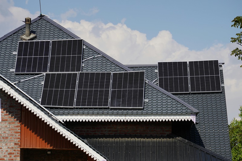 Residential Rooftop Solar Panel Installation Solar panels installed on a sloped roof of a brick house, under a blue sky.