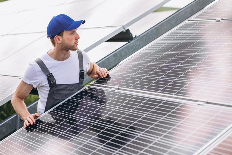 technician inspecting a large-scale solar panel