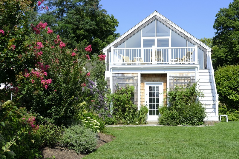 A white house with a porch and a deck