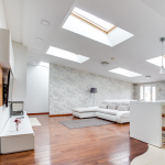 Bright modern living room with skylights open space and wooden flooring