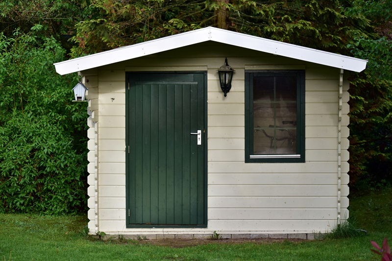 Charming Cream Wooden Garden Shed with Dark Green Trim