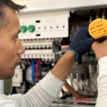 Focused technician using a drill on an electrical panel, showcasing expert workmanship