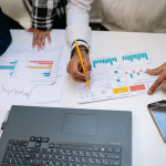 Modern Office Workspace with Laptop, Spreadsheet Charts, and Smartphone