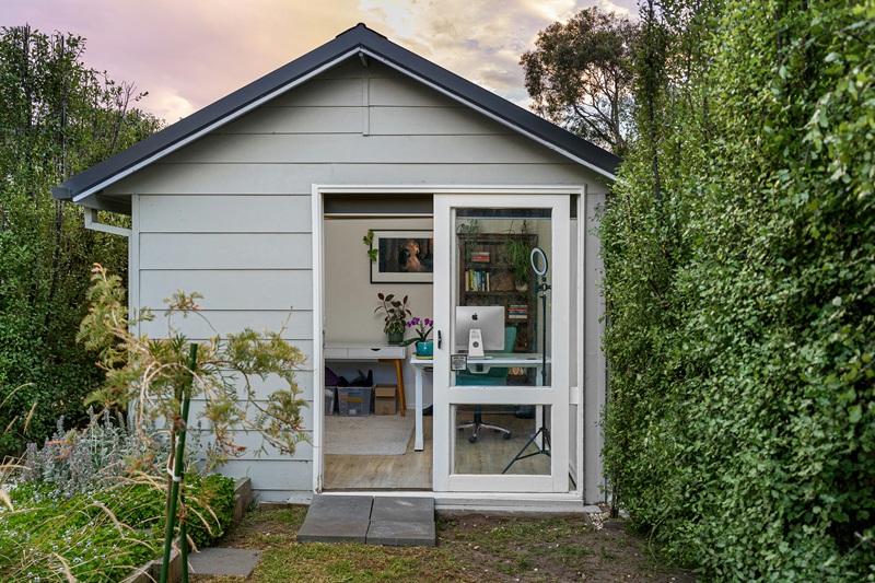 A small shed with a door open in a garden