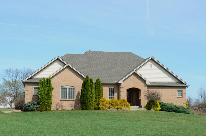 A suburban brick house with a well-kept lawn A suburban brick house with a well-kept lawn