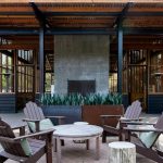An outdoor patio with a fireplace and adirondack chairs