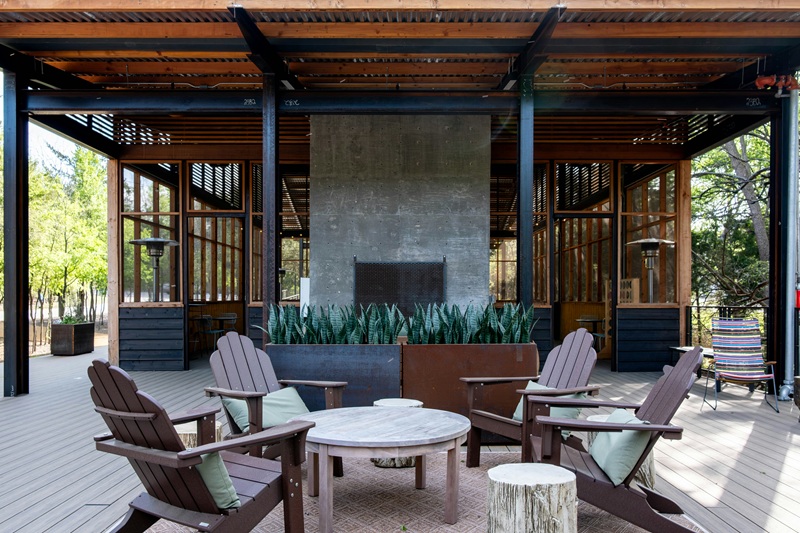 An outdoor patio with a fireplace and adirondack chairs An outdoor patio with a fireplace and adirondack chairs