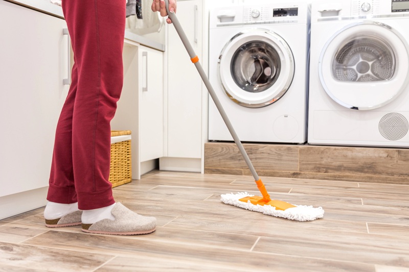 Cleaning floor in laundry room in modern house