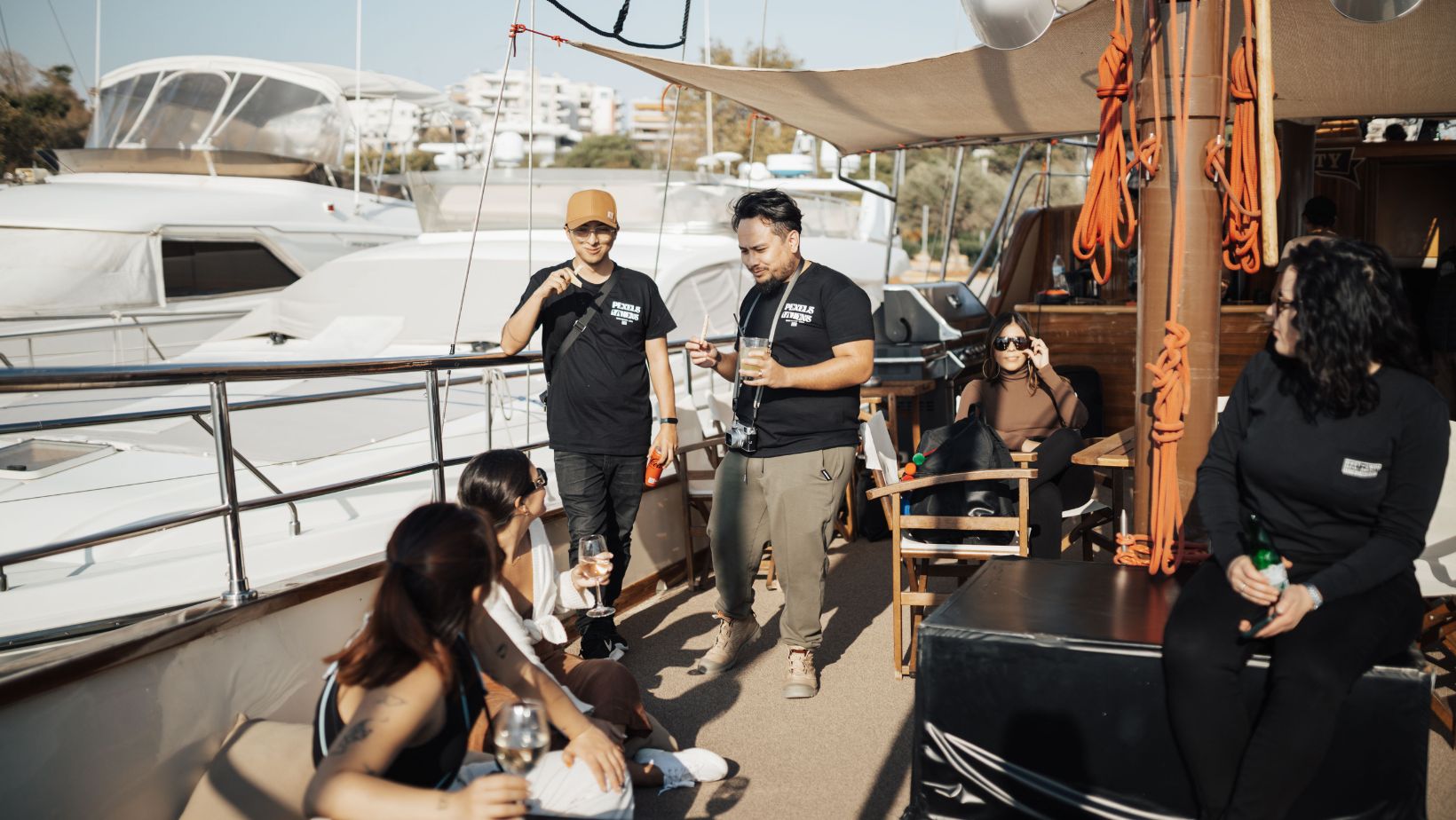 Friends enjoying a sunny day on a yacht docked at a marina, socializing and relaxing.