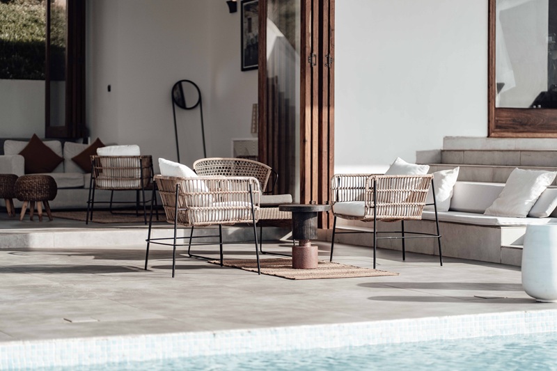 Luxurious outdoor seating area by the pool with modern wicker chairs and soft cushions Luxurious outdoor seating area by the pool with modern wicker chairs and soft cushions