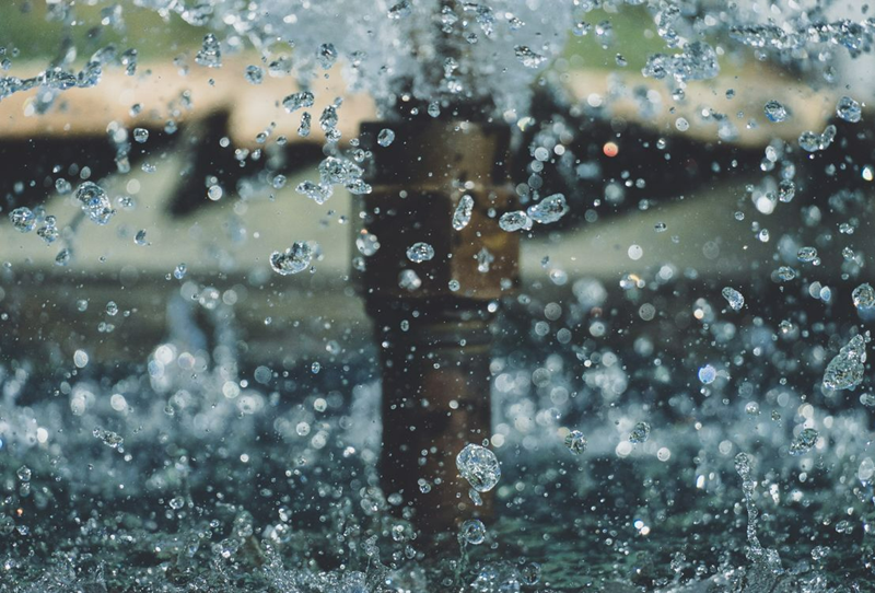 Macro Action Shot of Water Splashing from a Fountain Nozzle