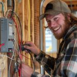 Smiling Apprentice Working on Residential Wall Wiring