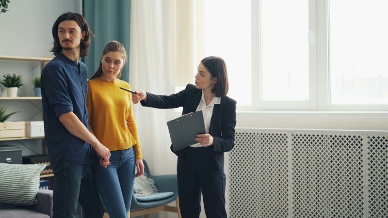 a group of people standing around a living room a group of people standing around a living room
