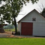 red and white wooden house near green tree during daytime
