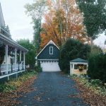 Driveway leading to a garage with autumn trees