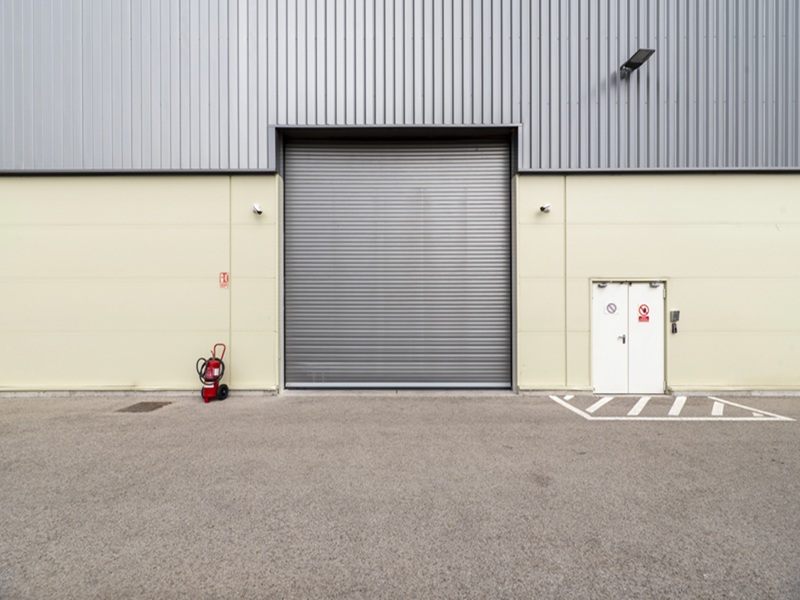 Gray industrial wall with roller shutter door and window