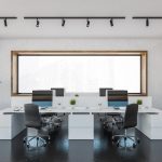 Office room with armchairs and computers on white tables