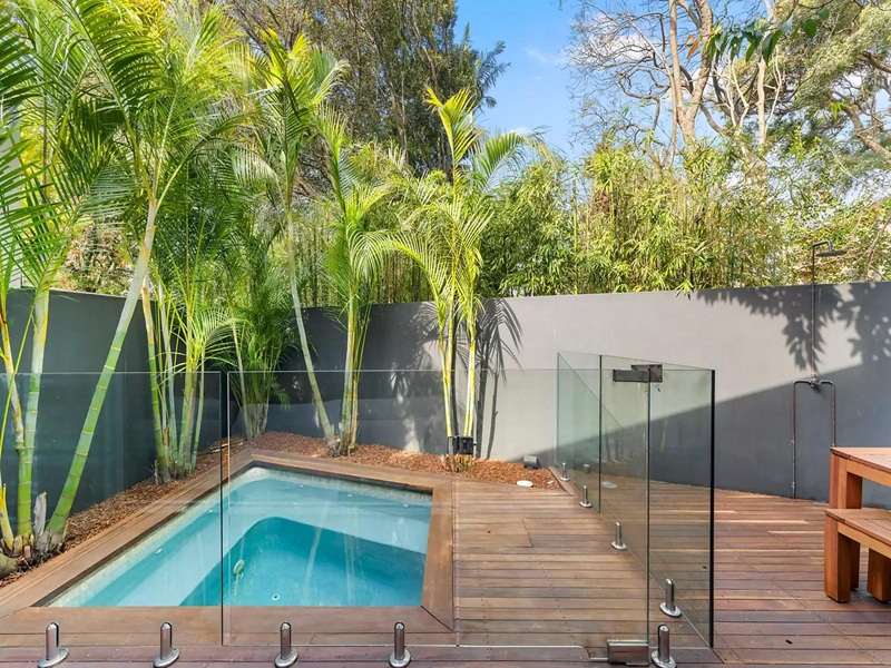 A small plunge pool in a landscaped Australian backyard, with timber decking, greenery, and a compact seating area. A small plunge pool in a landscaped Australian backyard, with timber decking, greenery, and a compact seating area.